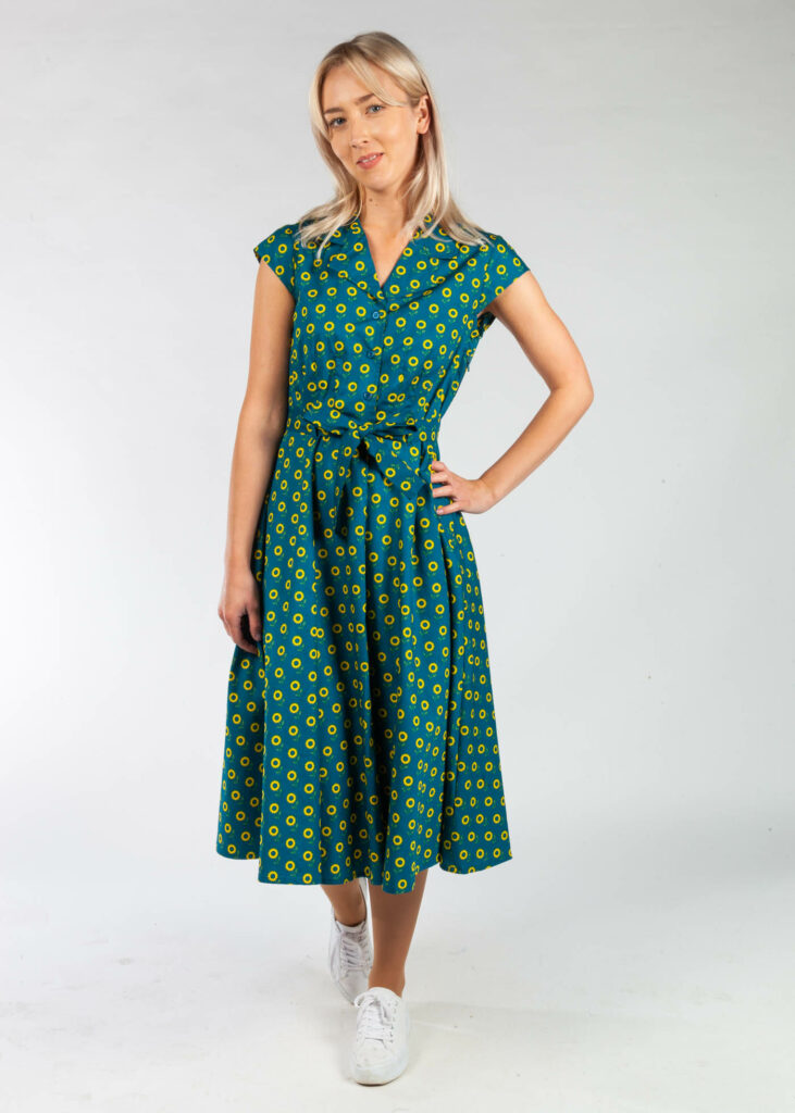 The Ava is a gorgeous shirt dress inspired by the glamour of the 1940s. Perfect your vintage style with elegant cap sleeves, a removable belt and a full a-line skirt. Featuring detailed yellow sunflowers printed on a rich blue cotton with teal undertones.